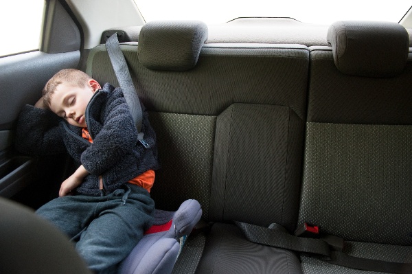 Mały chłopiec śpi w samochodzie na foteliku