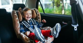 Roześmiane dziecko w foteliku samochodowym