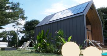 Widok na dom z panelami fotowoltaicznymi na dachu.