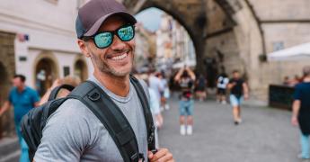 Uśmiechnięty mężczyzna z plecakiem na plecach.