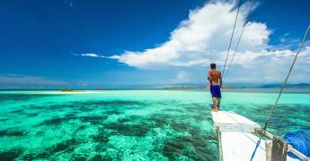 Sylwetka mężczyzny na tle przejrzystej wody oceanu.