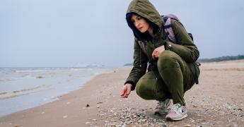 Kobieta w kurtce na plaży.